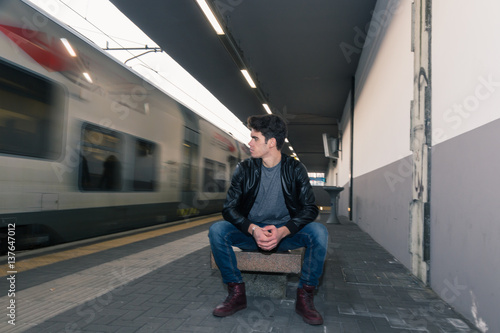 Beautiful young man posing in a train station