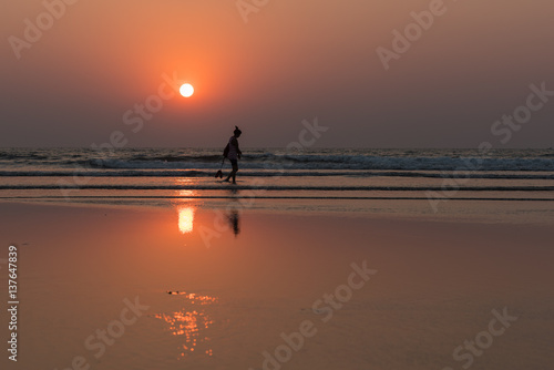 the person against the background of a sunset and the ocean