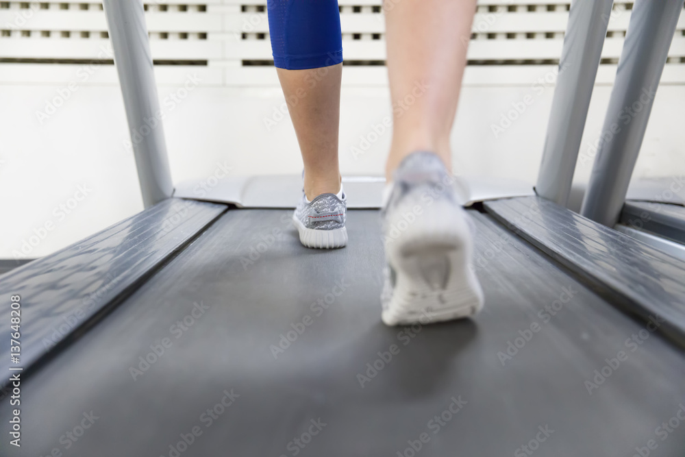 Fototapeta premium Fitness girl running on treadmill
