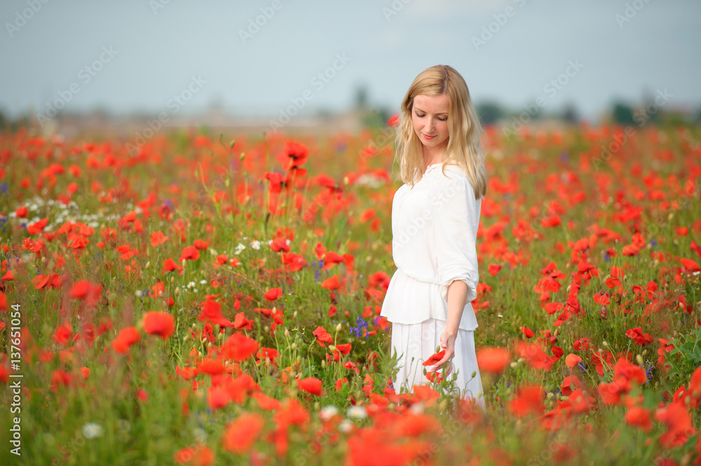 woman in white dress in the blooming poppy field woman in white dress in the blooming poppy field