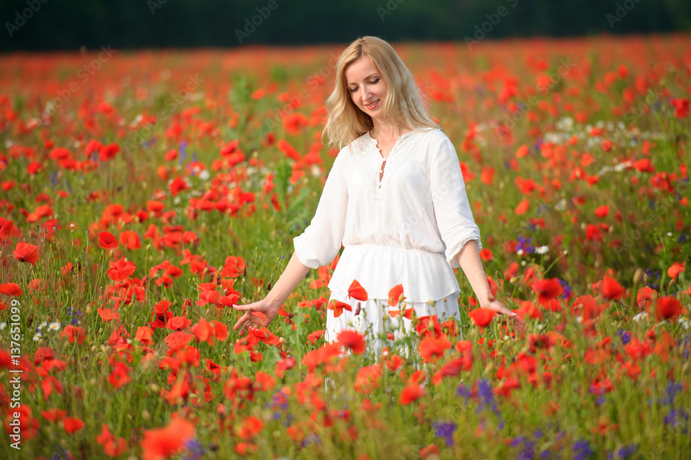 a woman in white dress at a summer blooming field a woman in white dress at a summer blooming field