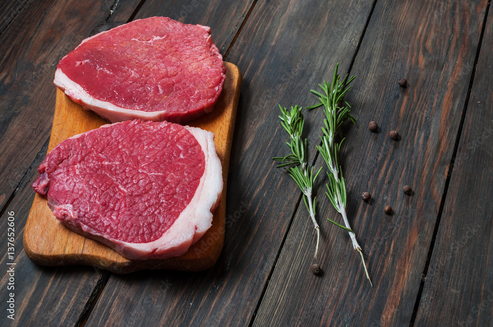 Fresh raw beef steak and chilli pepper on wood Fresh raw beef steak and chilli pepper on wood