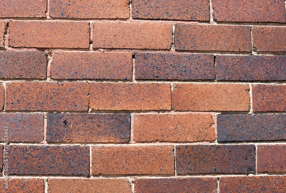 Fototapeta premium Imperfect, aged, red brick exterior wall