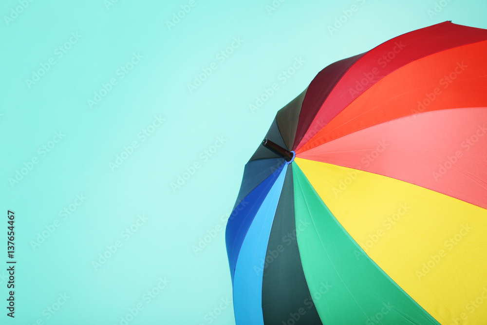 Colorful opened umbrella on green background