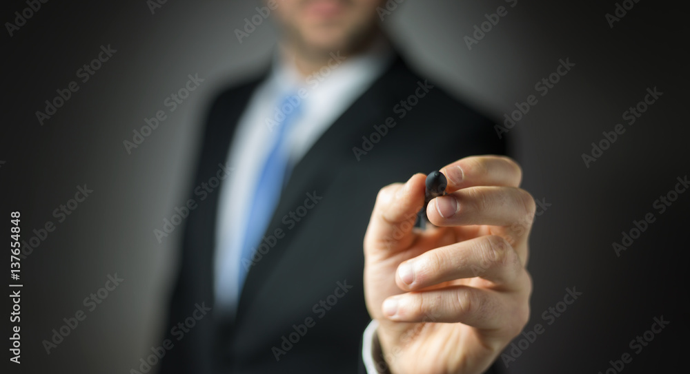 Businessman writing with a pen on a digital screen