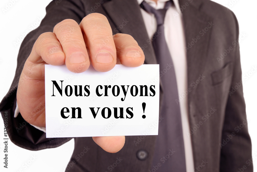 Homme tenant une carte avec écrit dessus nous croyons en vous Homme tenant une carte avec écrit dessus nous croyons en vous