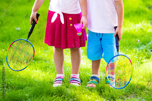 Kids play badminton or tennis in outdoor court