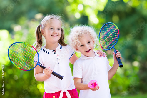 Kids play badminton or tennis in outdoor court © famveldman