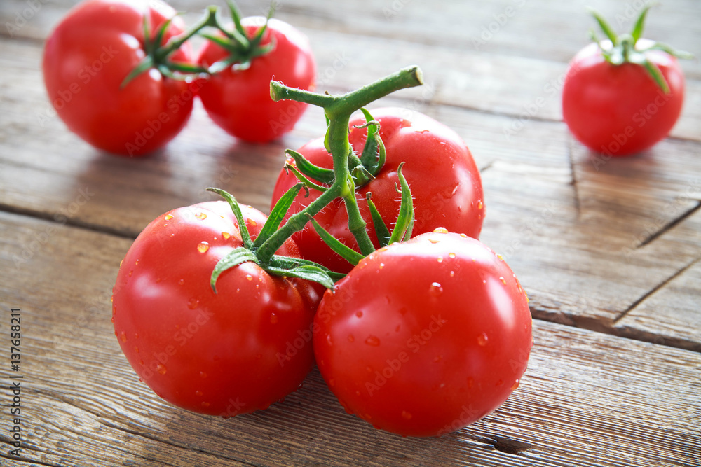 Sweet tomatoes isolated on wooden background Sweet tomatoes isolated on wooden background
