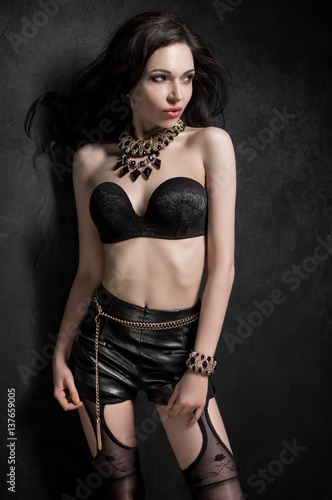 Young sexy woman in lingerie and leather skirt