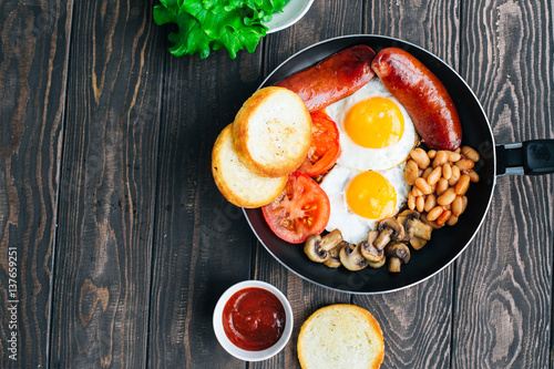 Breakfast tomatoes, sausages, beans, mushrooms, eggs,toast and herbs top view