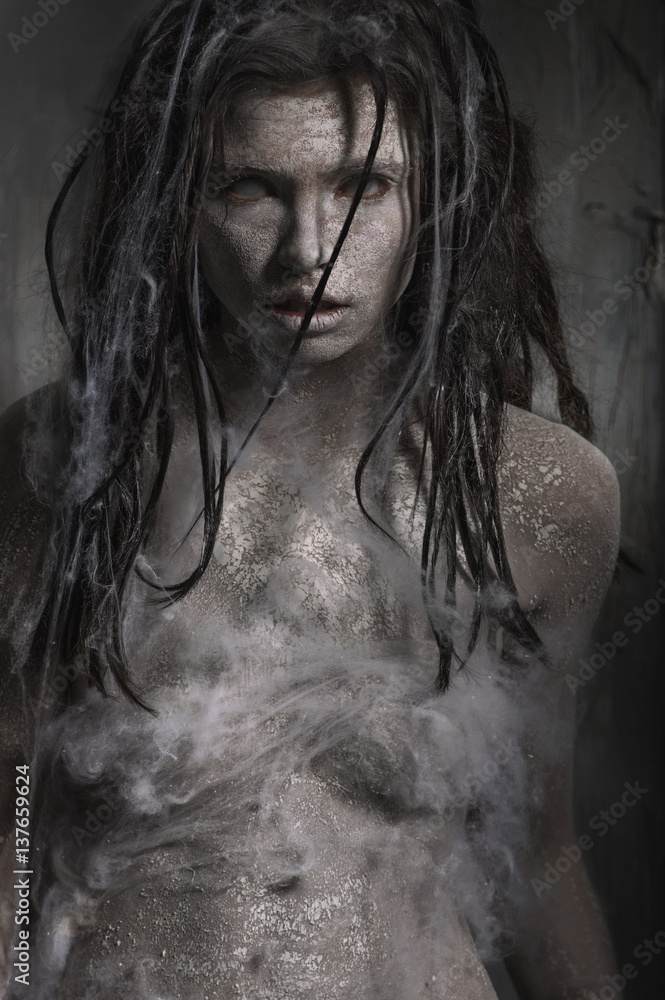 Dirty zombie woman with clay make up on dark background
