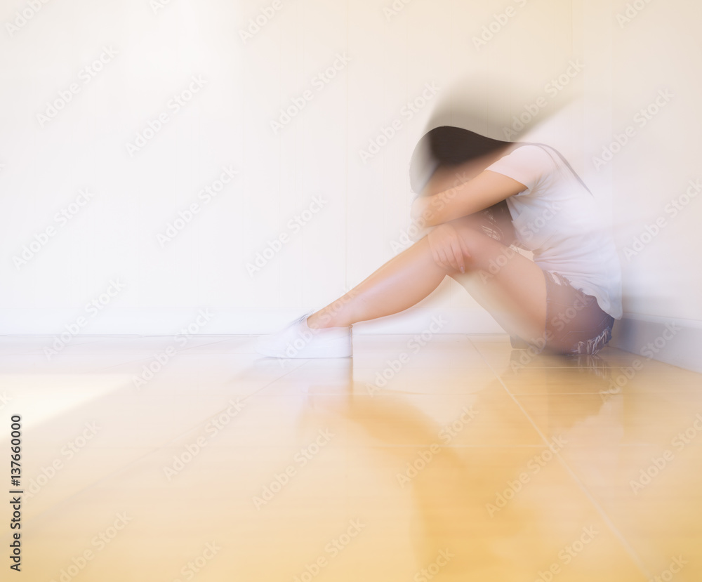 Woman sitting strain ,unhappy In the corner In the corner of the room, even when the light shines,blur Woman sitting strain ,unhappy In the corner In the corner of the room, even when the light shines,blur