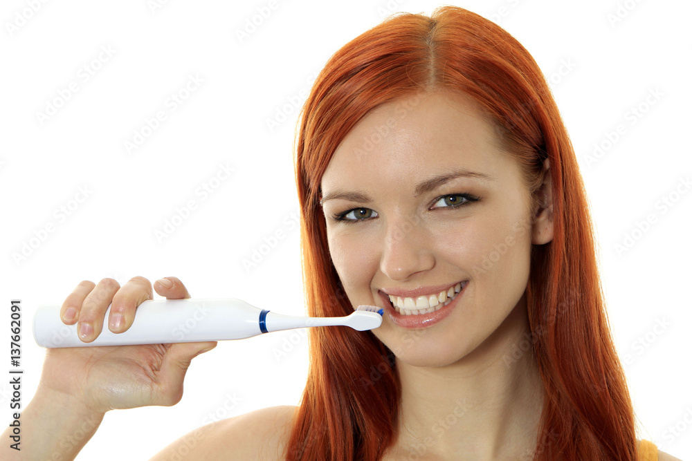 Young red-haired woman cleaning her teeth with a toothbrush Young red-haired woman cleaning her teeth with a toothbrush