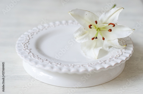 White lily on a white plate and a white background