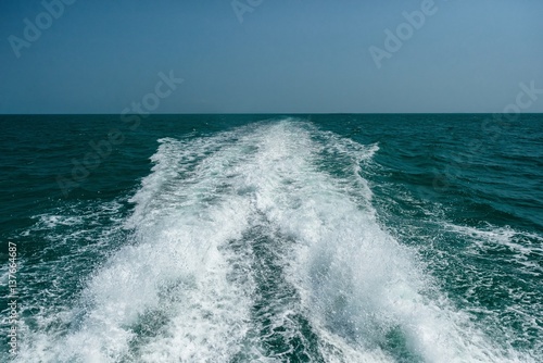 Acting wave behind motor boat at the vast ocean