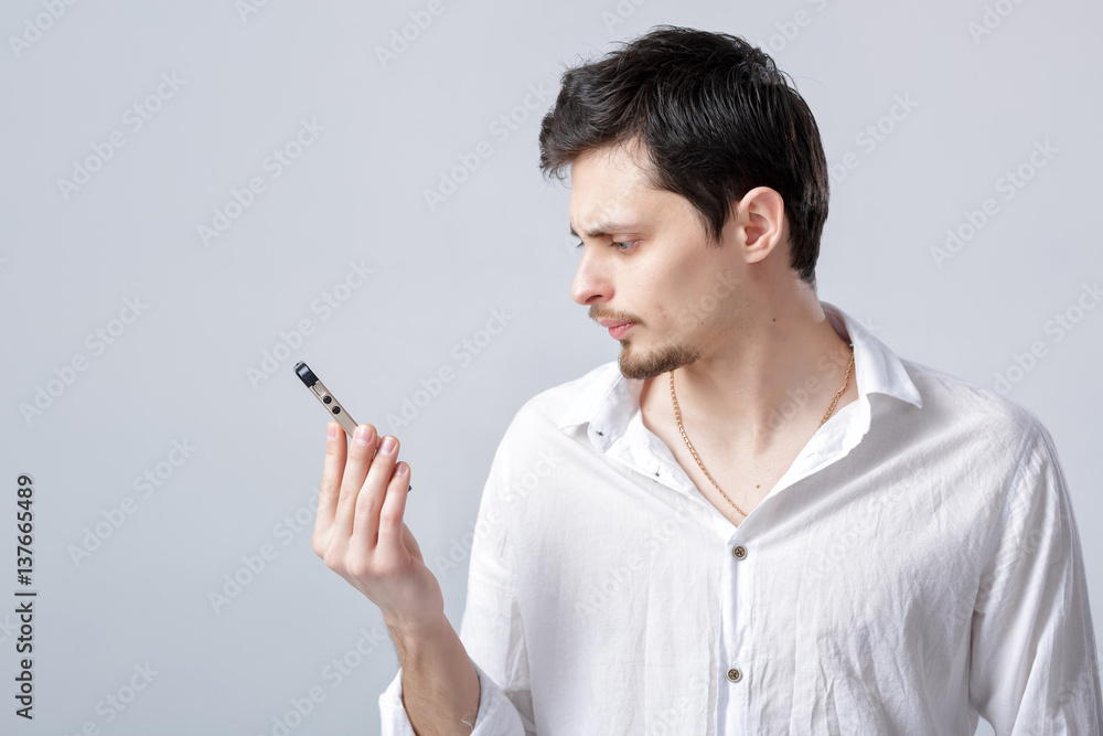 portrait of attractive young brunette man in shirt talking on sm portrait of attractive young brunette man in shirt talking on sm