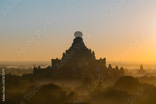 Hot air balloon over plain middle of Bagan in misty morning, Myanmar at sunrise