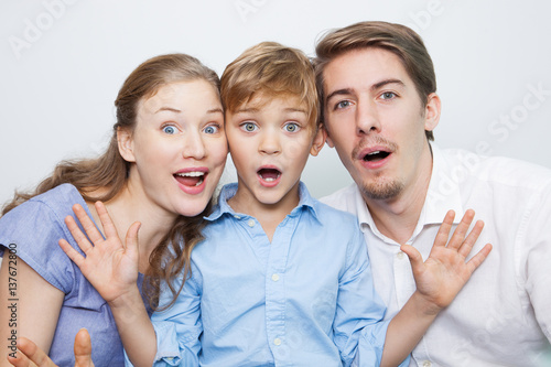 Portrait of surprised young family with little son