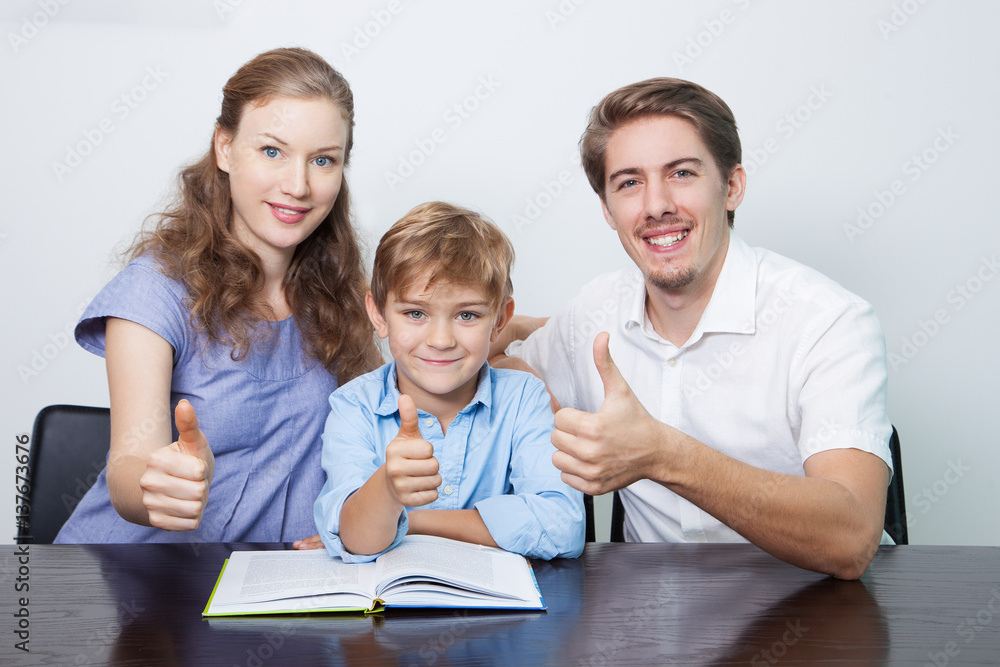 Happy Mom, Dad and Son Reading Book With Thumbs Up