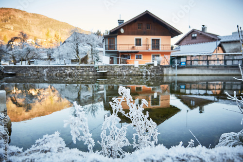 Fototapeta House at the river with frost and ice
