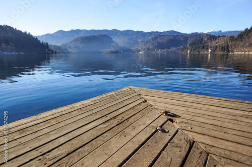 Wood pier on the Bled lake in Slovenia with famous island