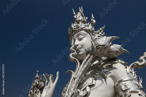 Sculpture detail with white Buddha in all-white buddhist temple Wat Rong Khun in Chiang Rai, Thailand, symbol of creativity, serenity and peace