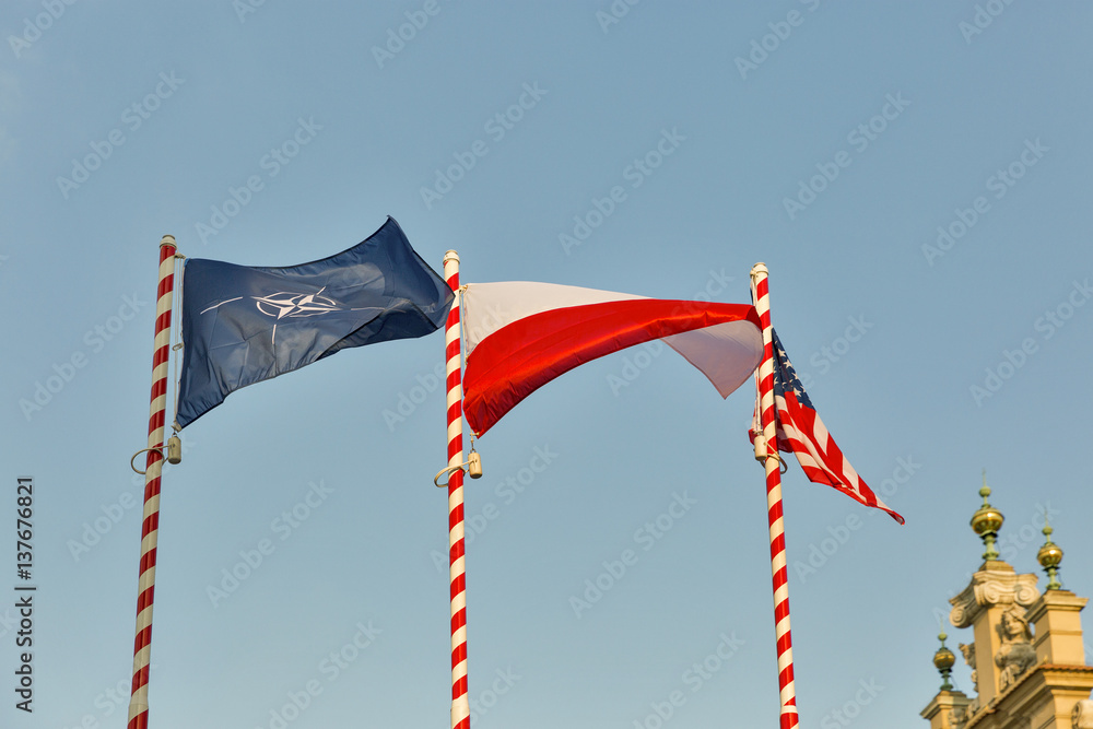 Φωτογραφία Flags of Nato, Poland and USA outdoor against clear blue sky.
