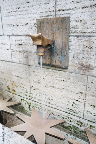 Water running from a tap of the natural source of Passy in the middle of Paris