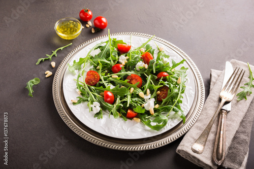 fresh vegetable salad with rucola, tomatos and goat cheese. Healthy food concept. Copy space.