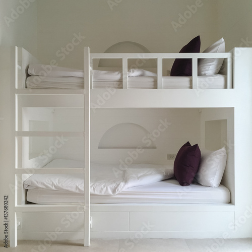 Clean hotel room with wooden bunk beds. Vintage effect style pictures.