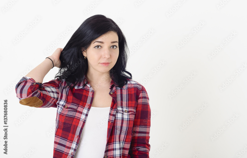 Beautiful girl in a red hipster plaid shirt corrects hairstyle t Beautiful girl in a red hipster plaid shirt corrects hairstyle t