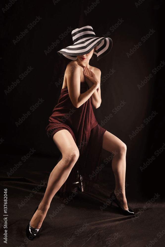 Fototapeta premium Beautiful naked woman covering body with brown cloth , a photo full length in the brown colors.