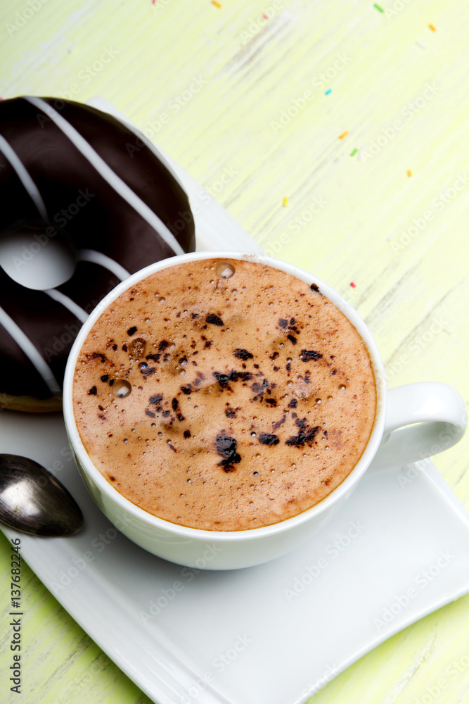 Cup of coffee and tasty donuts with icing and chocolate on green wooden background, copy space Cup of coffee and tasty donuts with icing and chocolate on green wooden background, copy space