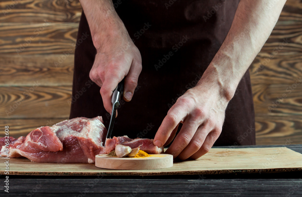 Butcher cutting pork meat