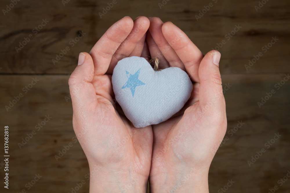 Obraz premium Heart from cloth on wood desk