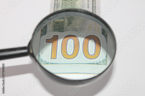 100 Dollars under magnifying glass