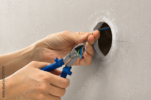 hands of electrician with wire cutter