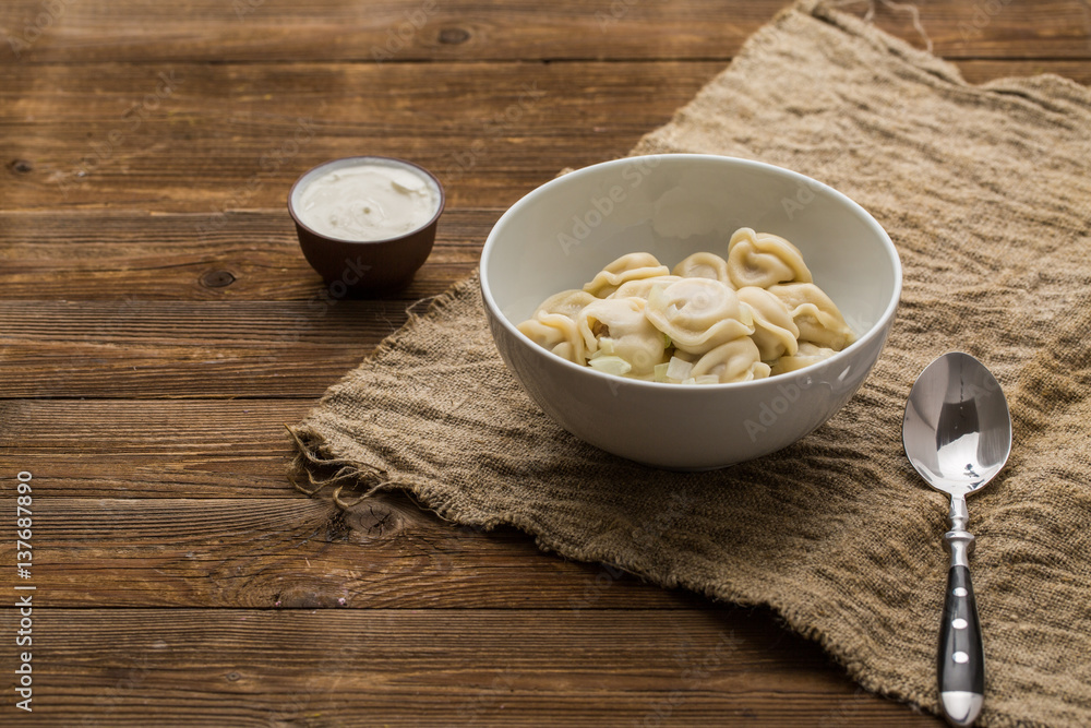 Meat dumplings - russian pelmeni, ravioli with meat on a white plate Meat dumplings - russian pelmeni, ravioli with meat on a white plate