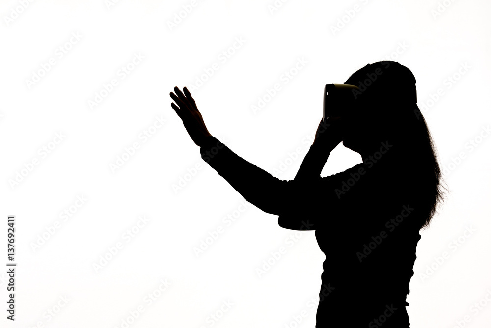 Silhouette of a woman playing with a Virtual Reality glasses. Silhouette of a woman playing with a Virtual Reality glasses.