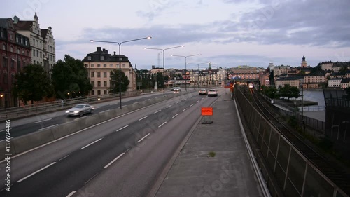 City traffic and railway tracks in Stockholm, Sweden. Cars and train passing by photo