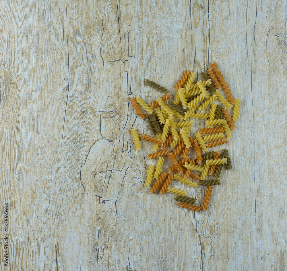 Fototapeta premium colored pasta on a wooden table