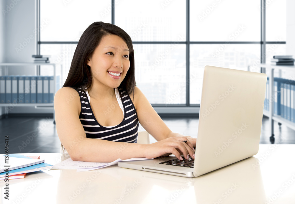 chinese asian woman working and studying on her laptop at modern office computer desk chinese asian woman working and studying on her laptop at modern office computer desk