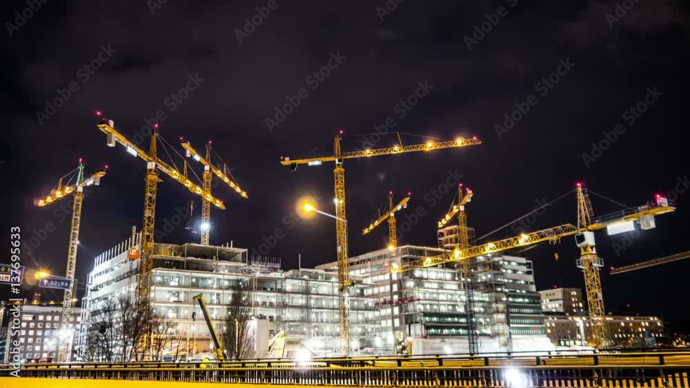 Construction site at night Time Lapse. Working tower cranes, buildings and traffic Construction site at night Time Lapse. Working tower cranes, buildings and traffic