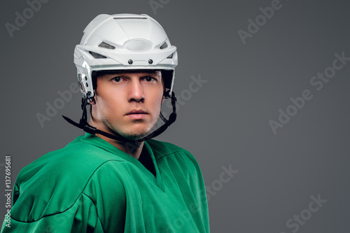 Portrait of hockey player isolated on grey background. © Fxquadro