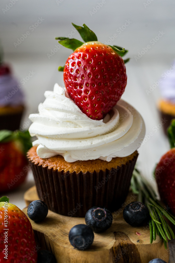 Chocolate cupcakes.Cupcakes with berries,fruit,strawberries. Top view.colorful cupcake,tasty cake,colorful cream,candies,cupcakes with summer berries on wooden background,close up,dessert concept Chocolate cupcakes.Cupcakes with berries,fruit,strawberries. Top view.colorful cupcake,tasty cake,colorful cream,candies,cupcakes with summer berries on wooden background,close up,dessert concept