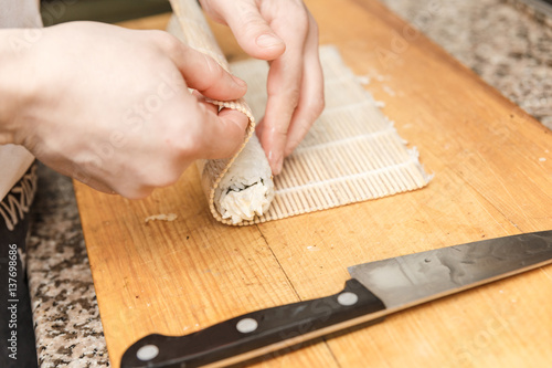 Preparing, rolling sushi.