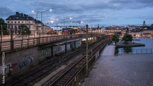 Time Lapse of city railroad tracks at night. Traffic passing by over bridge photo