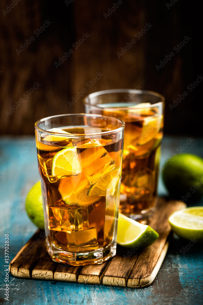 Cuba Libre or long island iced tea cocktail with strong drinks, cola, lime and ice in glass, cold longdrink Cuba Libre or long island iced tea cocktail with strong drinks, cola, lime and ice in glass, cold longdrink