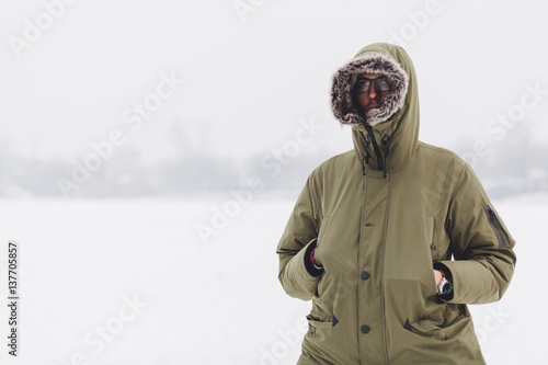 Young man in warm jacket in a cold winter day